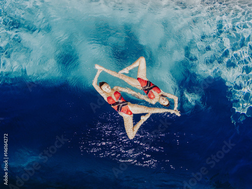 Aerial view of Caucasian synchronized swimmers photo