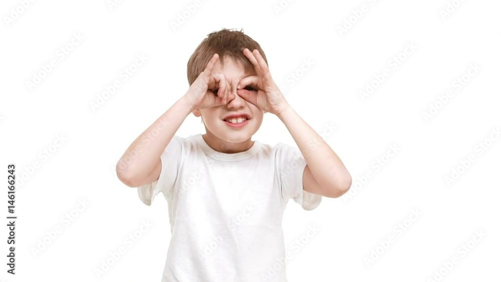 Elementary-aged Caucasian boy putting hands on face making funny faces standing on white background in slowmotion Elementary-aged Caucasian boy putting hands on face making funny faces standing on white background in slowmotion