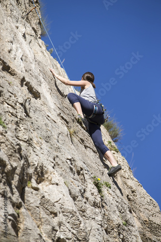 Young woman climbing. Rock climber.