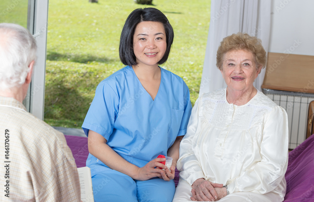 Nurse speaking with elderly woman in hospital bed Nurse speaking with elderly woman in hospital bed