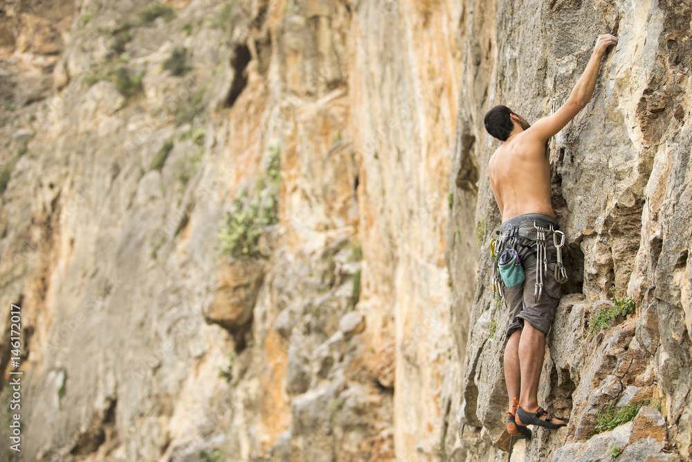 Young man climbing on a wall Young man climbing on a wall