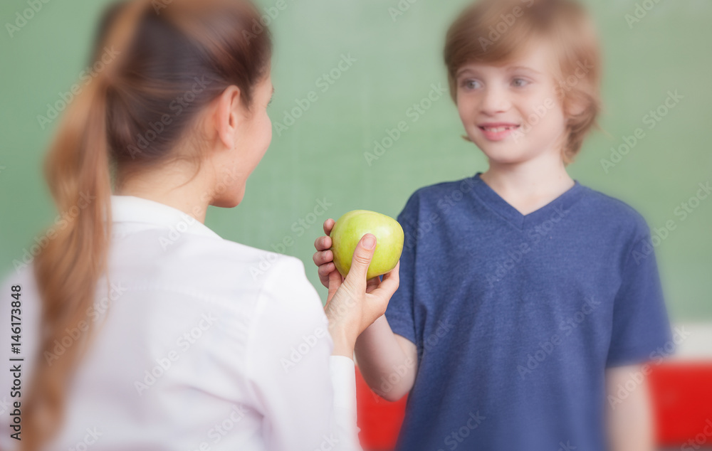 Teacher handing apple to student Teacher handing apple to student