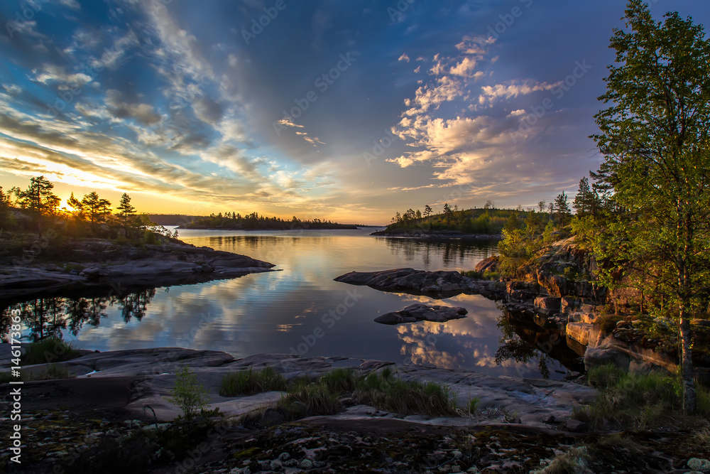 Obraz premium Rocky shore. Sunrise. Beautiful clouds over the water. Karelia. Ladoga lake.