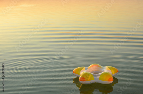 Swimming ring floating on calm water surface with soft waves. Atmosphere of calmness and serenity. Safety on water concept. Copy space.