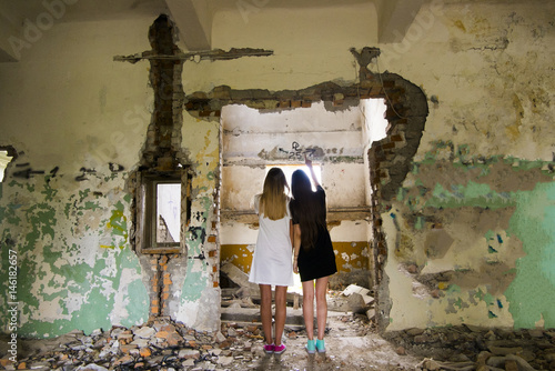 Women standing in doorway of dilapidated building