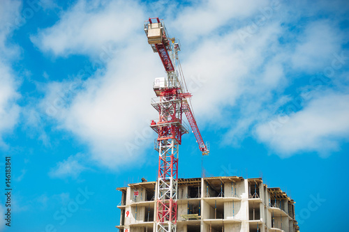 Construction site of multistore building with tower cranes and blue sky. Perspective view photo