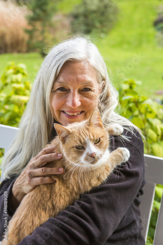 Portrait of smiling Caucasian woman holding cat photo