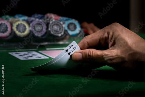 Game of blackjack at a casino with chips on a green blackjack table