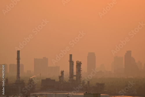 The oil refinery and cityscape in sunset time.