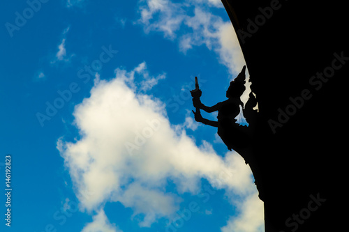 Dark Statue in front of the bright sky.