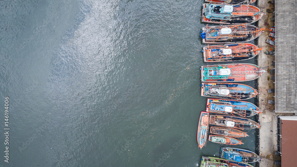 Big fishing boats standing at the sea in Phuket, Thailand. Aerial view from flying drone
