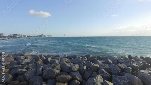 Miami Beach Bird Flying Out of Ocean Water Sunny Morning Rock Wall Pier photo