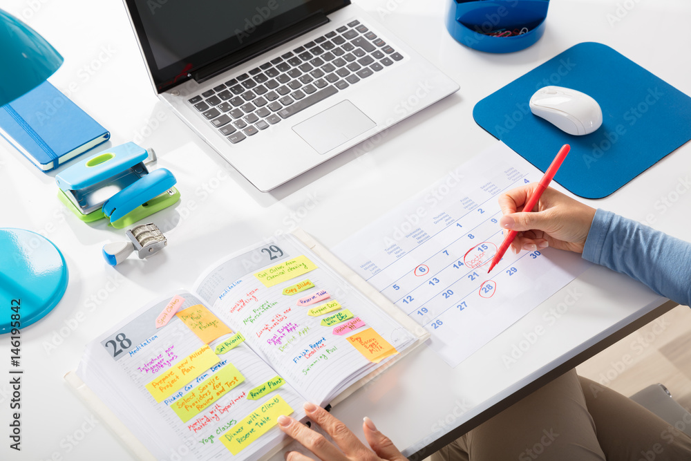 Businesswoman Marking Schedule On Calendar Businesswoman Marking Schedule On Calendar
