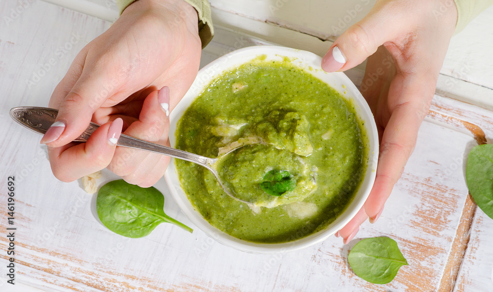 Woman hands with Bowl of green spinash soup. Woman hands with Bowl of green spinash soup.