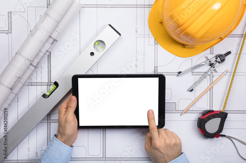 An Architect Touching The Screen Of Digital Tablet On Blueprint