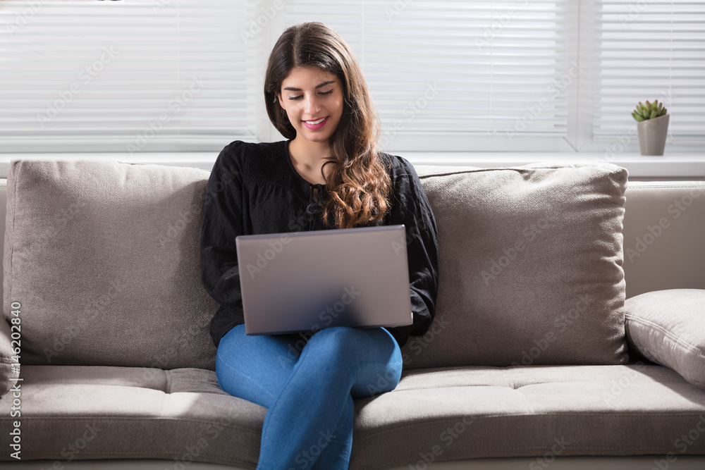 Smiling Woman Using Laptop At Home Smiling Woman Using Laptop At Home