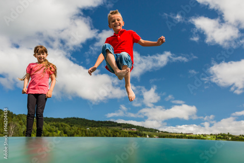 Children bouncing up and down on trampoline