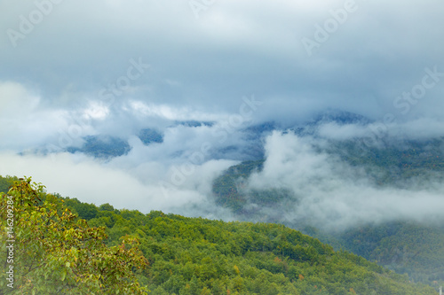 Tranquil panorama of mountain tops in the morning fog and clouds