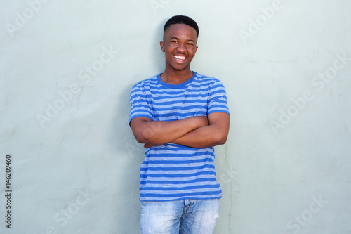cool young black guy smiling against wall