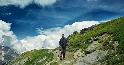hiker with backpack on the trail in the Apls mountains. Trek near Matterhorn mount © vitaliymateha