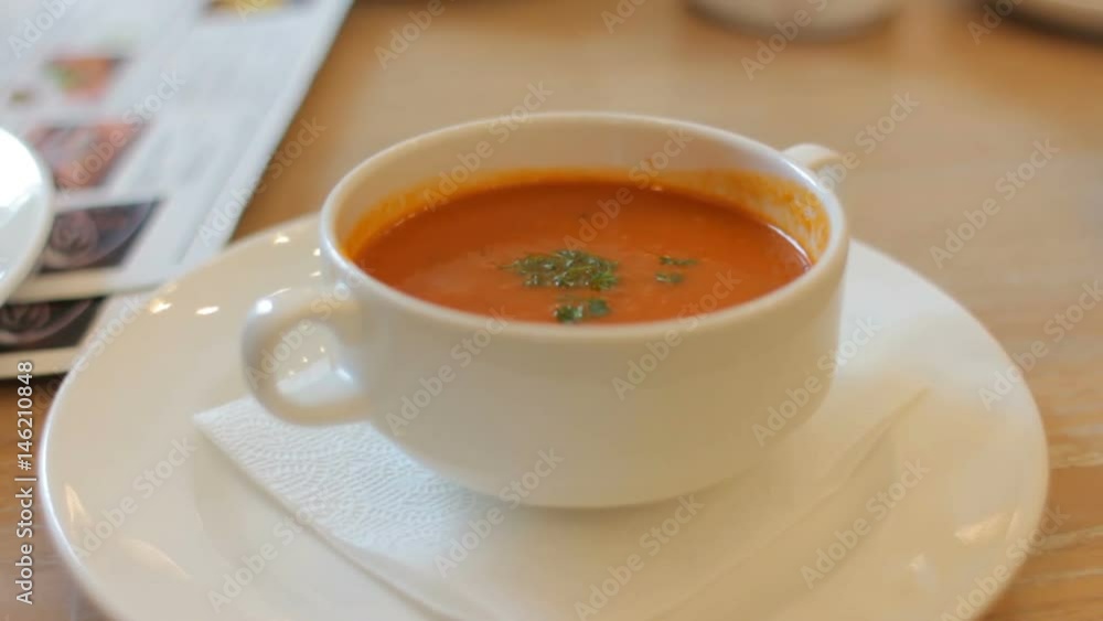 Bowl with tomato soup with green on table in cafe restaurant. Diet food Bowl with tomato soup with green on table in cafe restaurant. Diet food