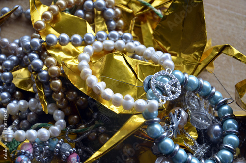 Pêle-mêle de bijoux en perles et de grues dorées origami