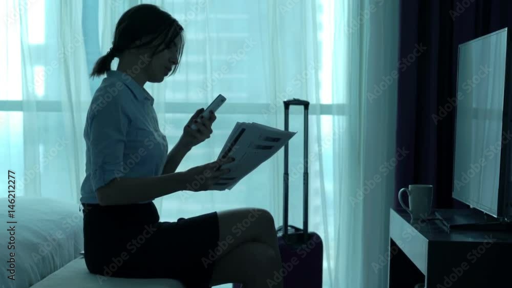 Businesswoman working with documents and smartphone sitting in hotel room
Businesswoman working with documents and smartphone sitting in hotel room