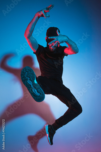 Fotografie, Obraz The silhouette of one hip hop male break dancer dancing on colorful background