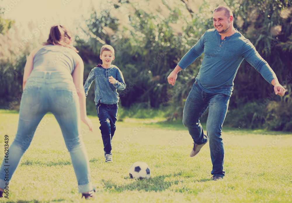 family running with ball on field.
