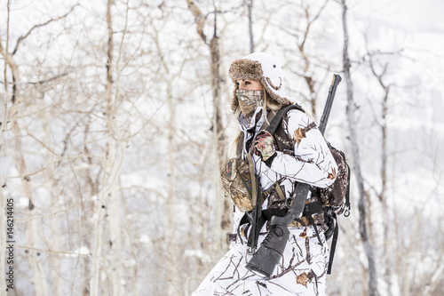 Caucasian woman hunting in forest wearing bandana