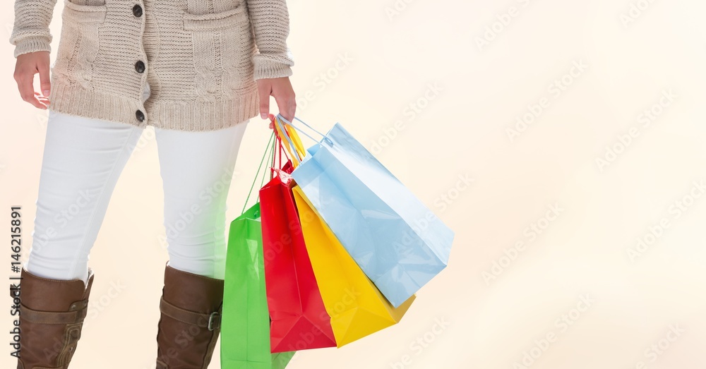 Midsection of woman with colorful shopping bags