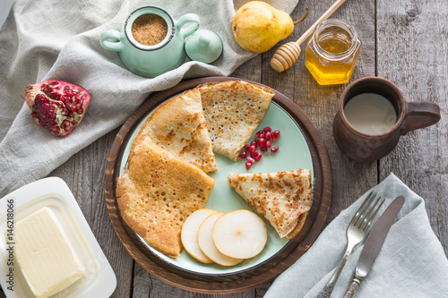 Tasty traditional russian breakfast of pancakes with honey on plate. Rustic style.