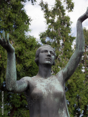 Bronze statue praying with his arms turned to heaven