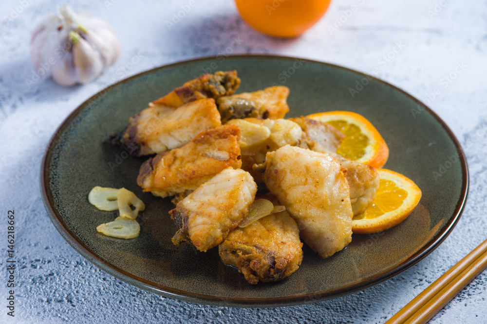 fried fish fillets flavored with garlic and orange fried fish fillets flavored with garlic and orange