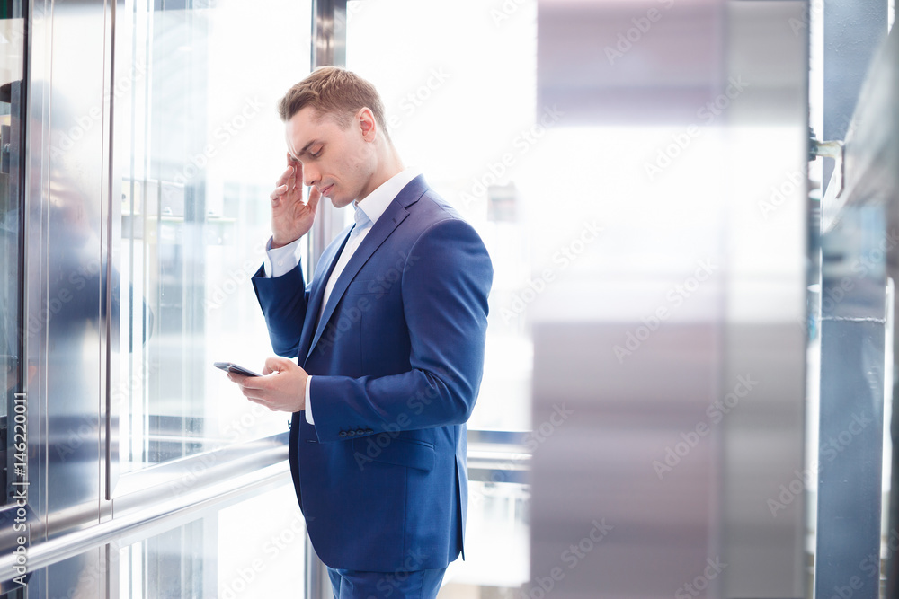Businessman standing in open Elevator, portrait, front view Businessman standing in open Elevator, portrait, front view