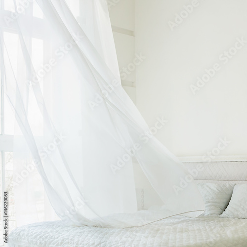 Abstract white waving curtain in white bedroom