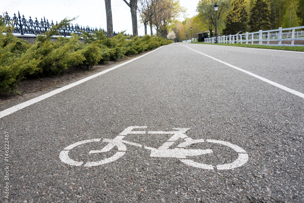 Obraz premium Bicycle sign on the road. Bike lane in the park