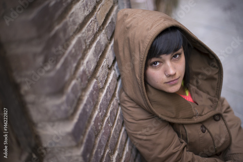 Young modern looking woman staring at camera, with a coat.