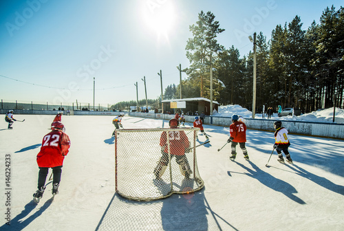 Caucasian boys playing ice hockey outdoors photo