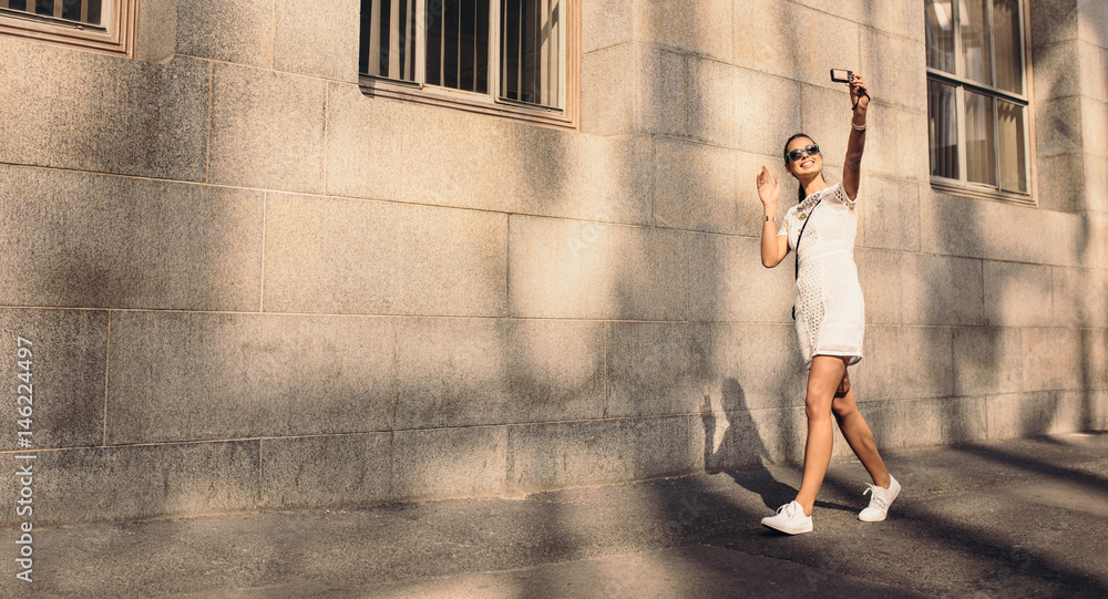 Young tourist taking a selfie walking in the street. Young tourist taking a selfie walking in the street.