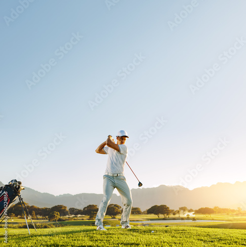 Male golf player teeing-off with driver