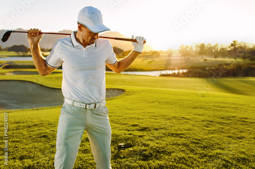 Golfer with golf club at course on a summer day