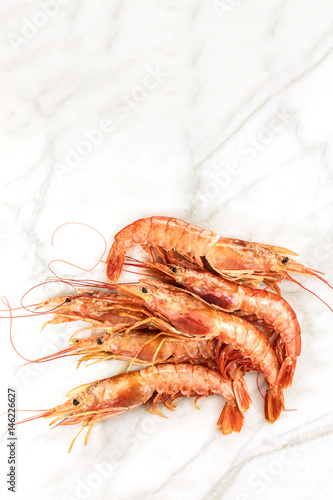 Raw shrimps on white marble with copyspace