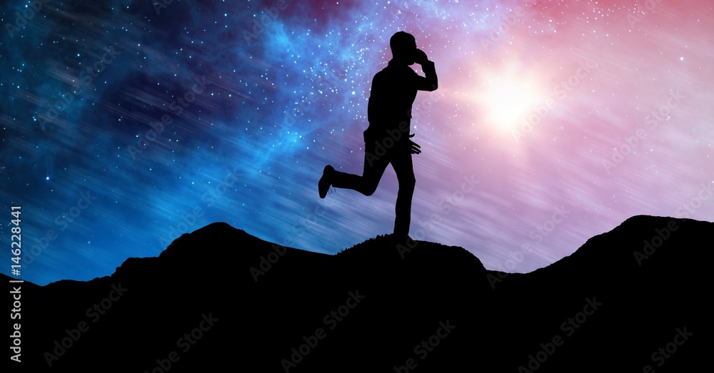 Silhouette businessman running on mountains against sky at night