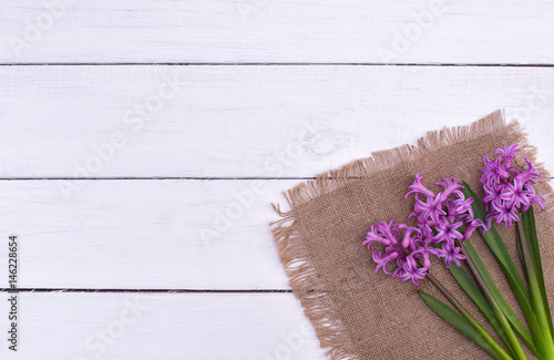 Fresh pink flowers hyacinths on white wooden table. Top view  copy space.