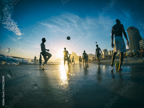 Silhouettes playing beach football on Ipanema Beach in Rio de Janeiro, Brazil photo