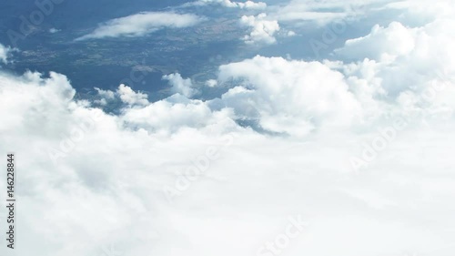 3D CGI animation of flying through white clouds towards ground visible from distance 