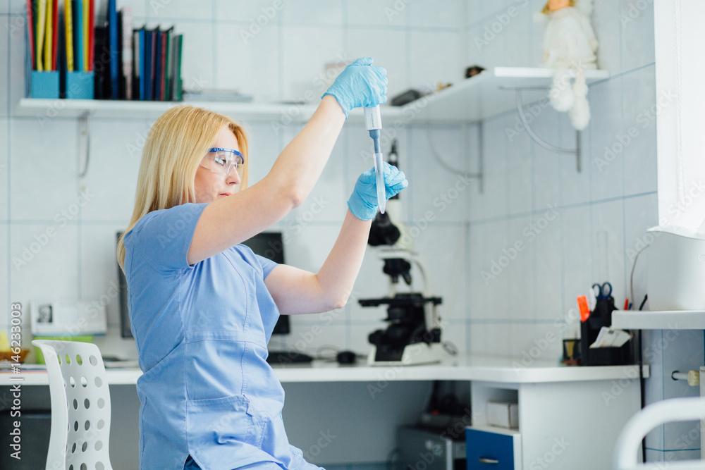 Chemical laboratory scene: attractive young female scientist observing the holding a test tube. Chemical laboratory scene: attractive young female scientist observing the holding a test tube.