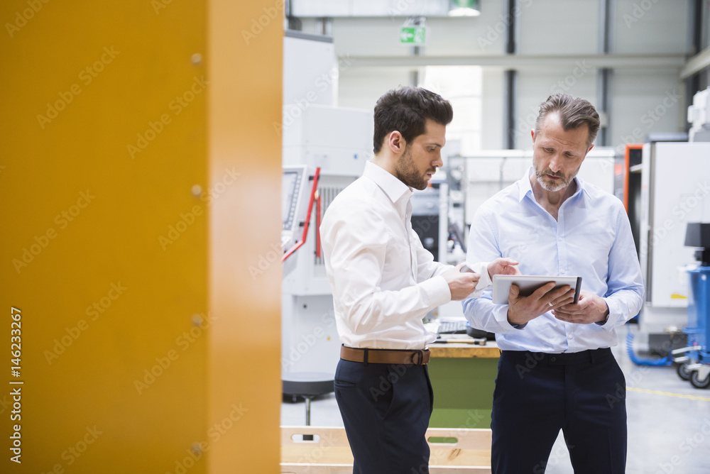 Two men with tablet and product in factory shop floor Two men with tablet and product in factory shop floor