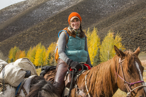 Smiling Caucasian woman riding horse in winter photo